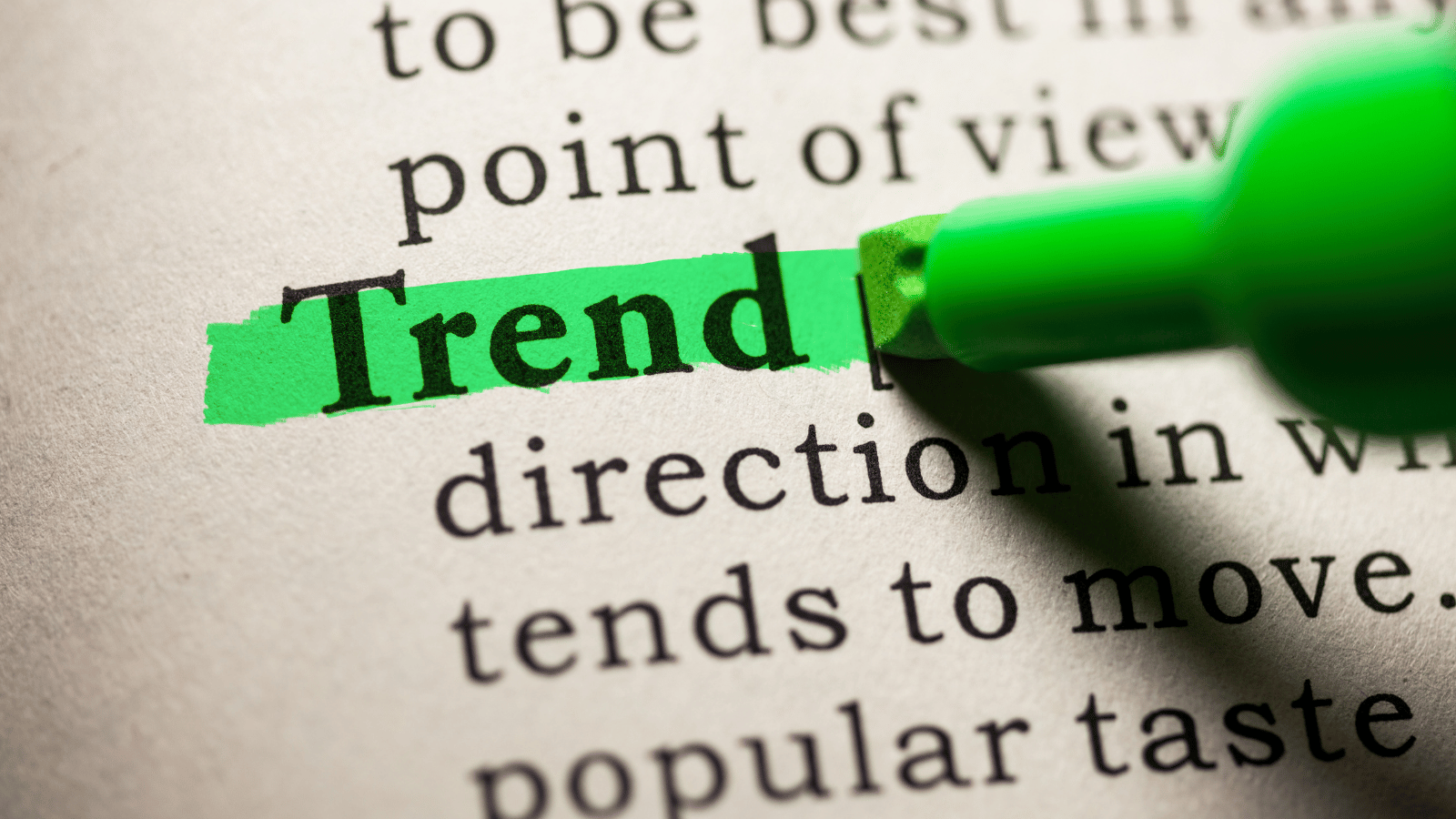 Close up of a dictionary description of the word 'trend.' A green highlighter is enhancing the word 'trend' with a green line.